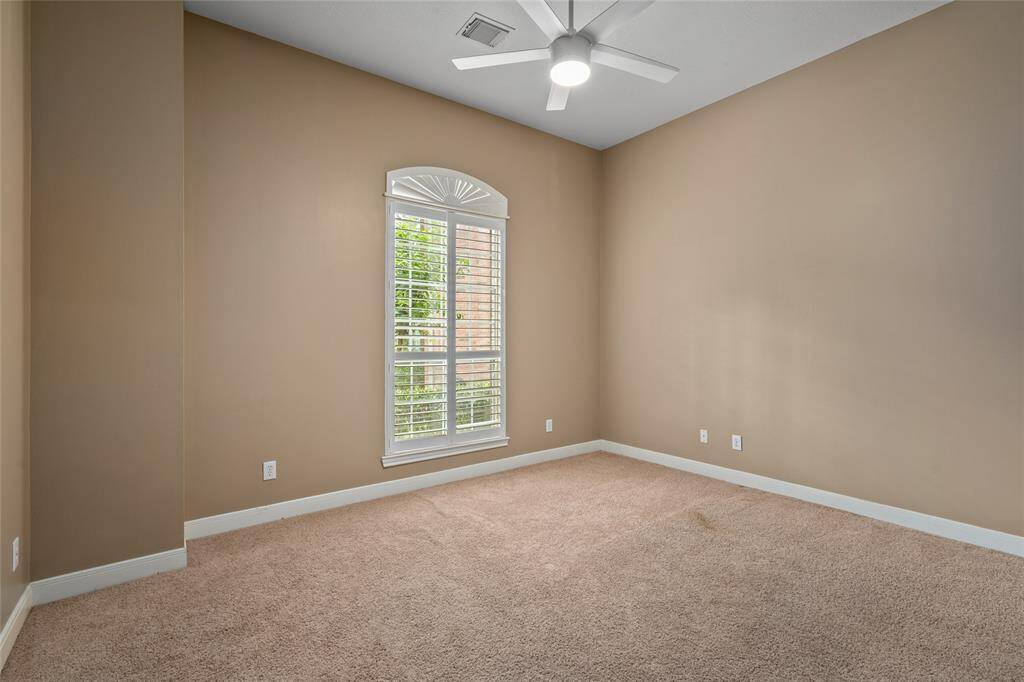 Another cozy secondary bedroom, featuring plush carpet and rich, darker earth-toned paint that creates a warm and inviting atmosphere. This room offers a serene retreat, perfect for a guest room, office, or personal space with a touch of character.