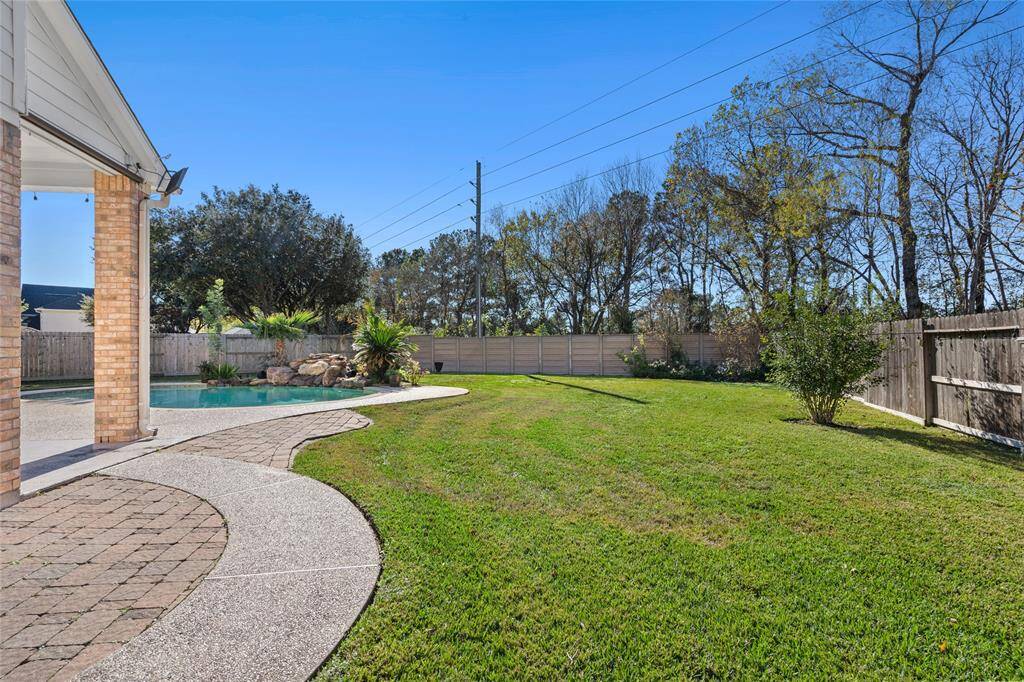 This side view of the house offers a sneak peek of the sparkling pool, showcasing its inviting shimmer and adding to the home's appeal. The glimpse of the pool from this angle gives you a taste of the outdoor oasis, perfect for relaxing and entertaining.