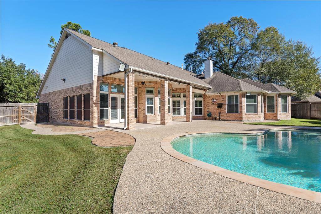 This view showcases the sparkling pool and the covered back porch, creating an ideal space for both relaxation and outdoor entertaining. The porch provides a shaded retreat, while the pool offers a refreshing escape, making this area perfect for enjoying the outdoors year-round.