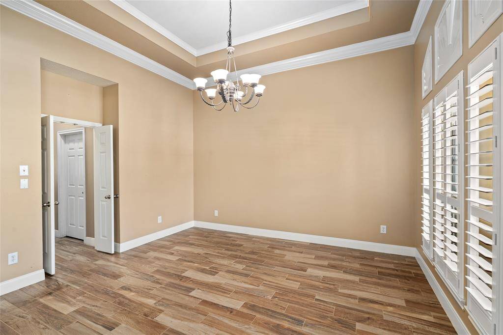 This versatile space can serve as a formal dining room, featuring a stunning wall of windows that floods the room with natural light. The bright and airy ambiance makes it the perfect setting for family gatherings or intimate dinner parties, while also offering a serene view of the outdoors.