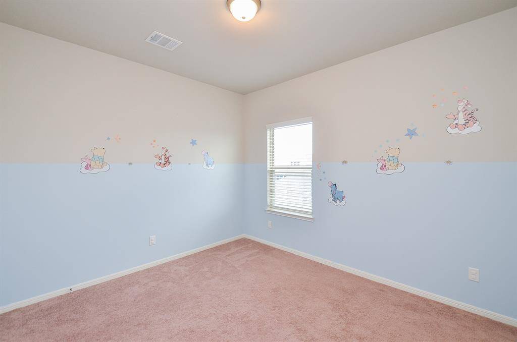 Another secondary bedroom welcomes family and staying guests.