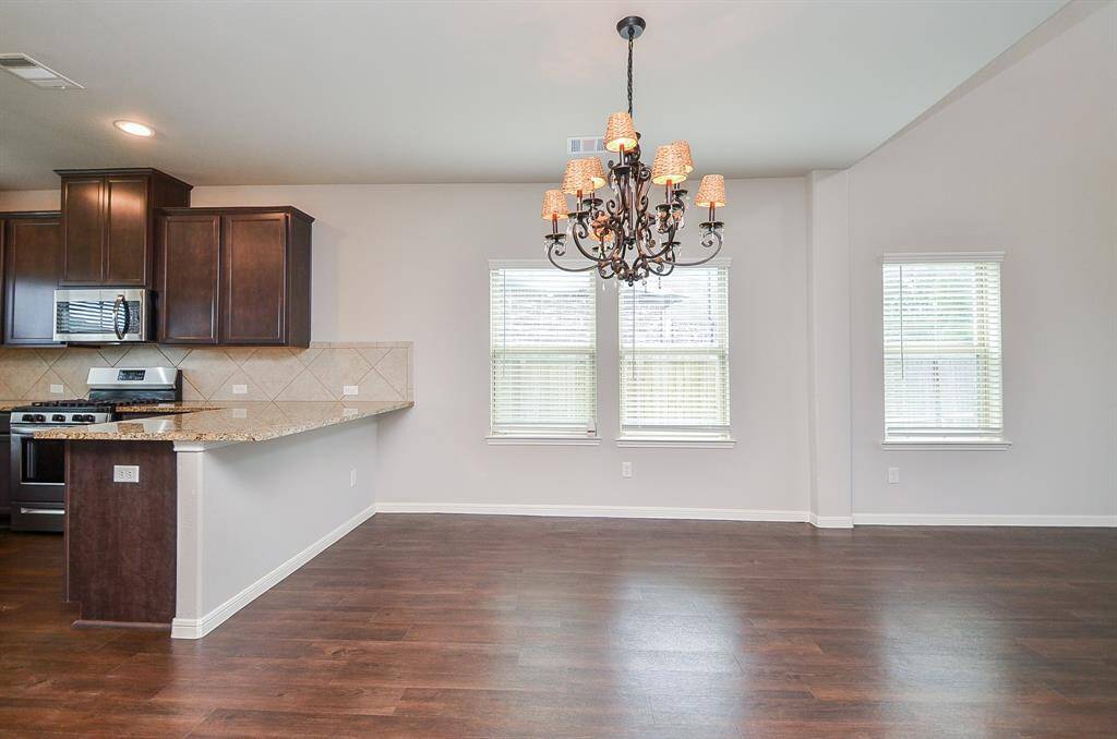 The compact, yet truly workable kitchen features rich dark cabinetry, up and down, with creamy granite counter tops and good looking tile backsplash.