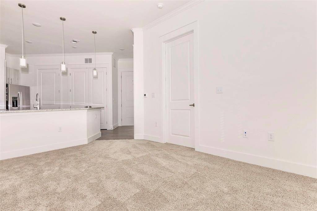 Kitchen with breakfast bar, modern white wood grain cabinetry, stainless steel appliances, and under cabinet lighting