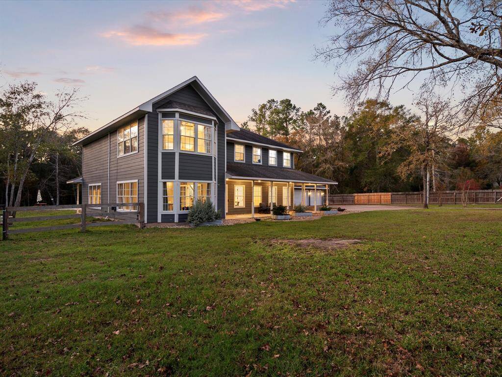Golden hour glow —this expansive backyard view showcases the home’s elegant architecture, inviting windows, and peaceful setting on 2+ acres.