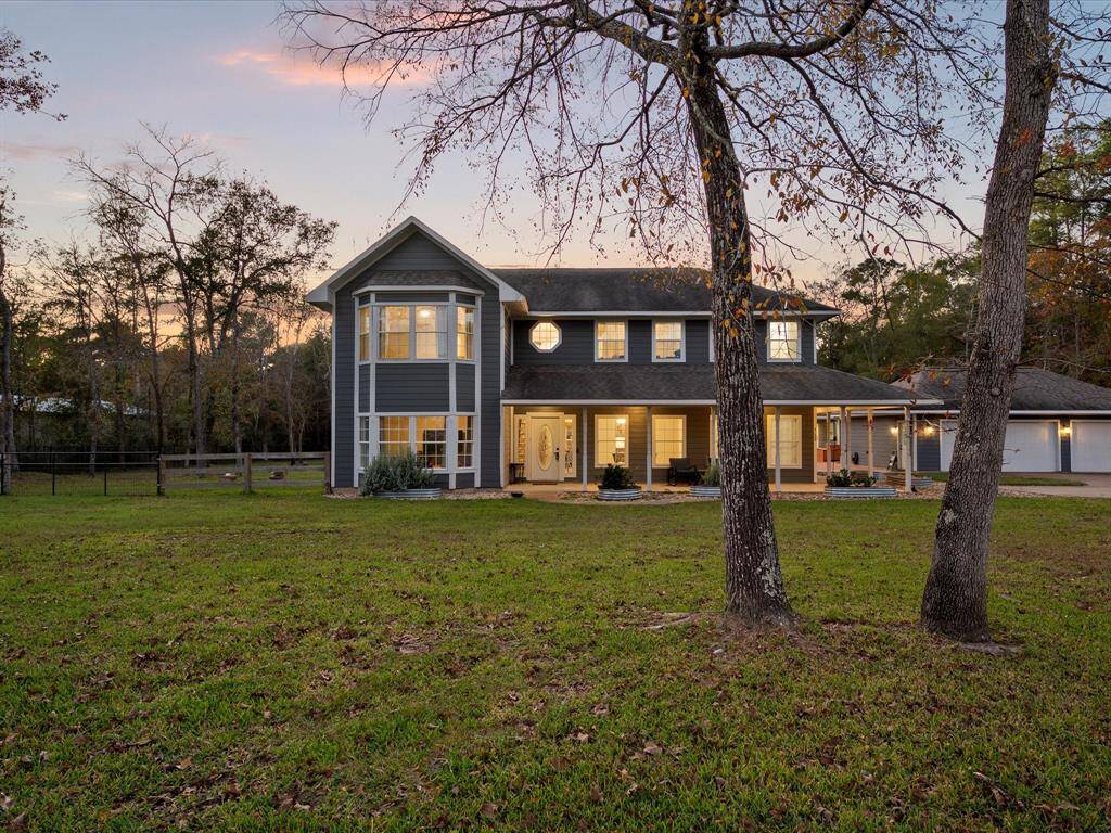 Another charming twilight angle of the backyard highlighting the wraparound porch and warm lighting inside—true country comfort meets style.