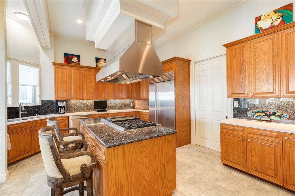 Kitchen is very well appointed with a Viking range and vent hood, Sub Zero fridge/freezer unit and double ovens. Behind the door in view is a large pantry area with shelves & and the utility room.