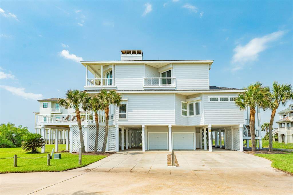The home sits on two lots at the end of Rum Bay. Lots of parking, two car garage and an immense ground floor patio area with outdoor shower and a staircase leading up to the front deck, and another up to front door.