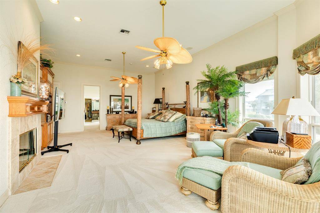 Primary bedroom includes a wood burning fireplace and built in shelving plus an entertainment cabinet.
