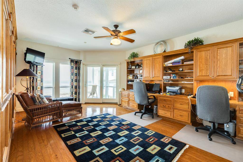 Next to upper level family room is a large room currently used as a home office space with built in desks, shelving and below counter drawers for files, etc. On the wall opposite of the built-in desks, there is a queen size Murphy bed retracted into the custom woodwork wall.