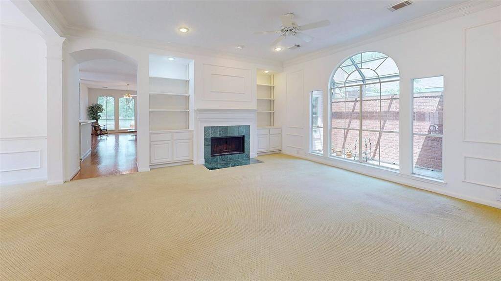 Another view of the living room with nice fireplace and built in cabinetry.
