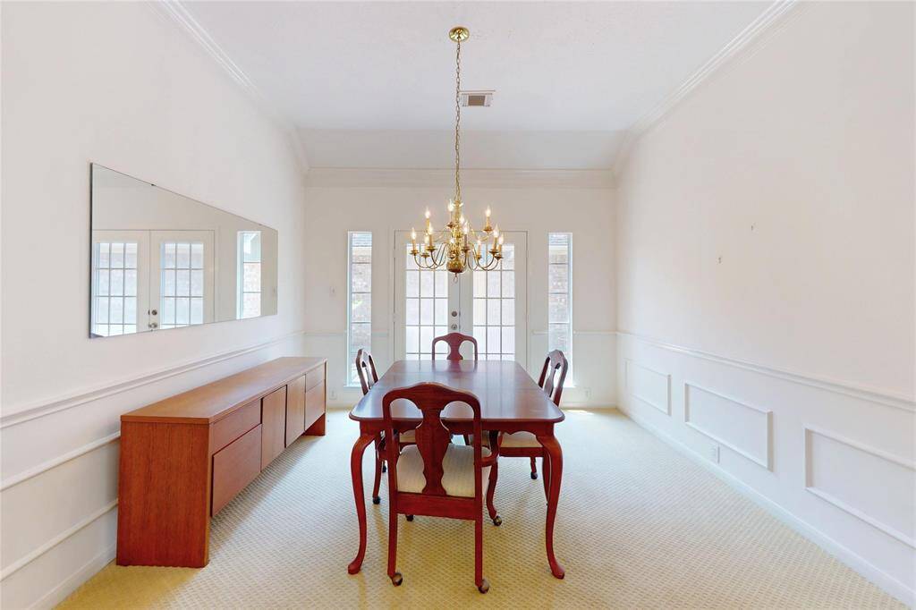 Formal dining room has french doors leading to a small patio on the side of the home.