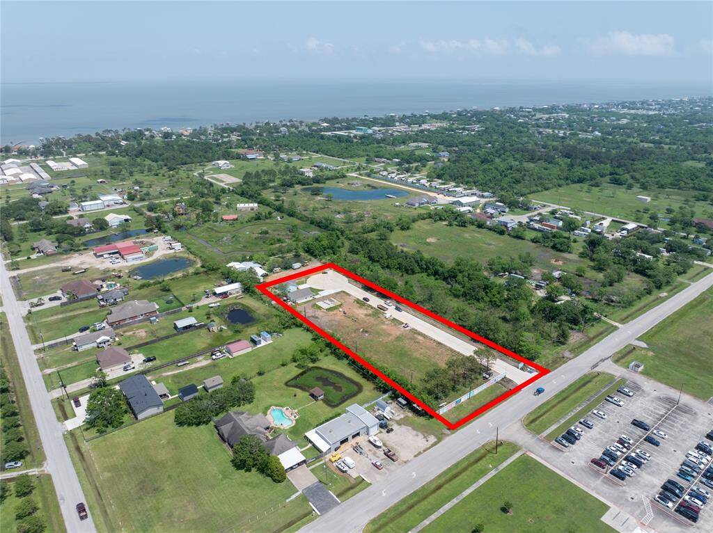 Aerial view of a spacious property outlined in red, with 8 residential lots and 8 more residential lots on the other side of the cul-de-sac, located in a semi-rural neighborhood with nearby homes and greenery.