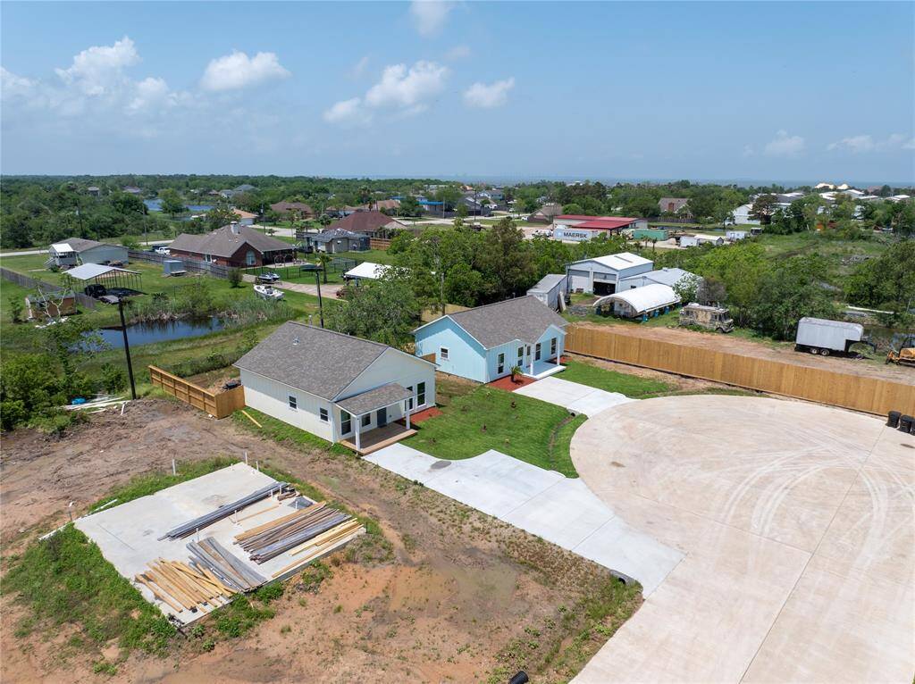 Two new single-story homes with driveways are situated in a peaceful neighborhood on a cul-de-sac. The area features a mix of homes, greenery, and a serene suburban setting.