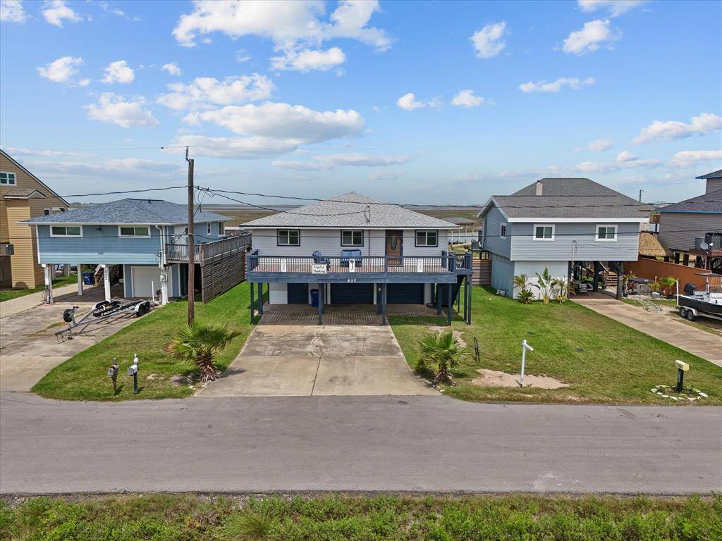 This aerial photo showcases a waterfront property with direct canal access, surrounded by a lush landscape and nearby residential homes. Ideal for boating enthusiasts and fisher-people, the house is conveniently located near open water and offers scenic views.