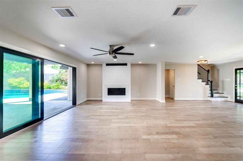 Large panoramic sliding glass patio doors overlooking yard & pool.