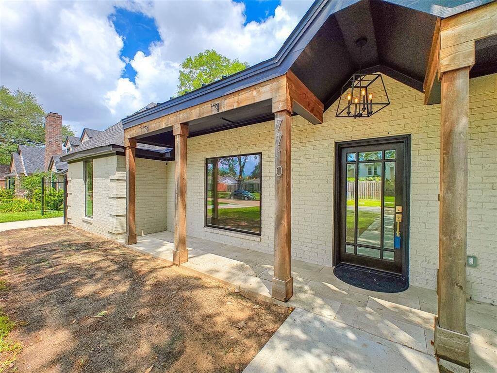 Custom front porch w/ metal roof & chandelier.