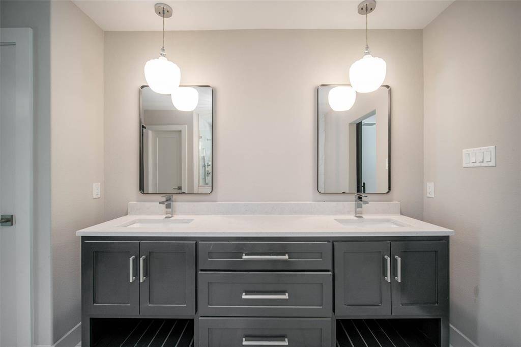 Dual vanities. Quartz counters. Framed mirrors.