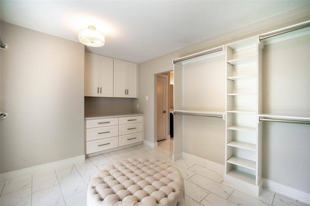 Oversized primary walk-in closet w/built-ins & sitting area.