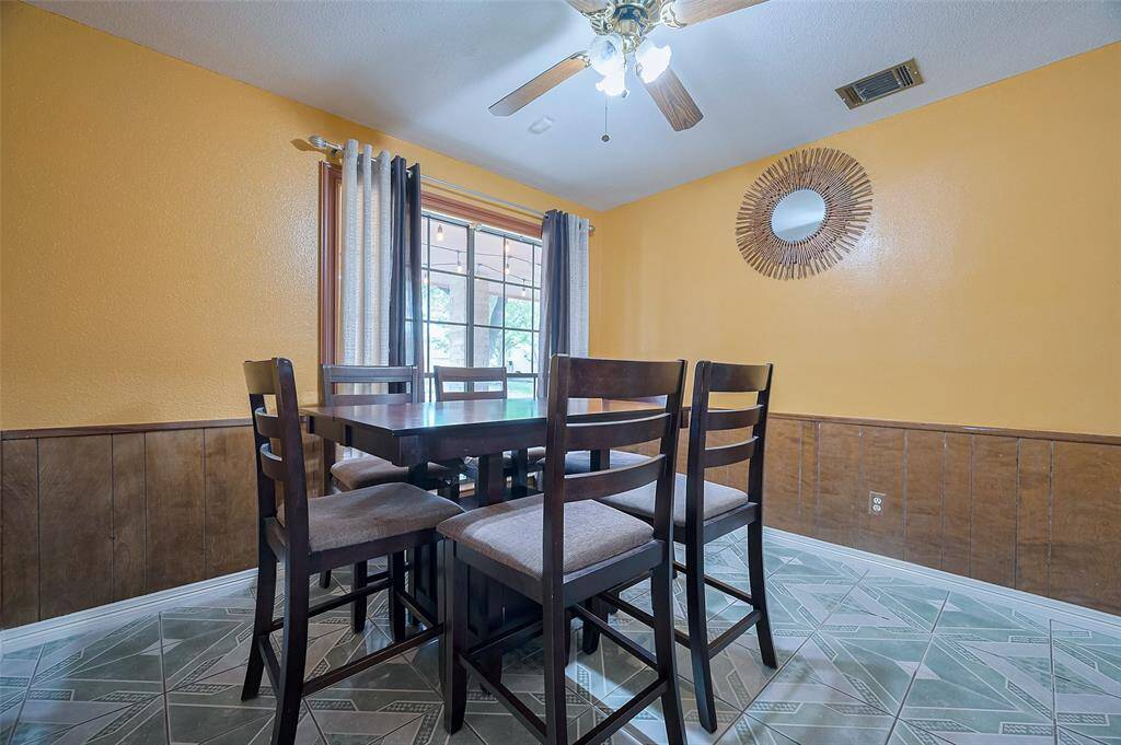 The charming breakfast area (10'11" x 10'7") features a ceiling fan and a window that looks out to the porch and front yard, creating a peaceful spot to enjoy your meals. With tile flooring for easy cleanup, it's the perfect space for dining together with family and friends.