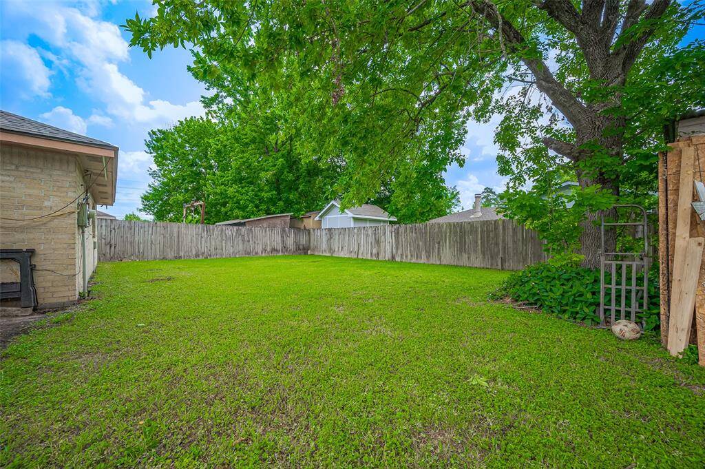 The grassy backyard offers plenty of potential to create your dream outdoor space. With a large, open area, you have the freedom to design a lush garden, build a play area, or even add a backyard retreat. The possibilities are endless, giving you the opportunity to personalize this space for family fun, relaxation, or entertaining.