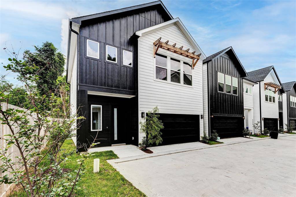 Modern two-story home with a sleek black and white exterior, featuring large windows and a spacious driveway. Ideal for contemporary living. Easy access to The Heights and all the restaurants as well as airport and downtown