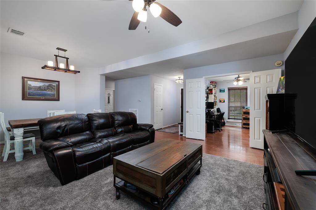 Another angle of the main living area looking towards front entrance and a room that can be used as a study/home office.