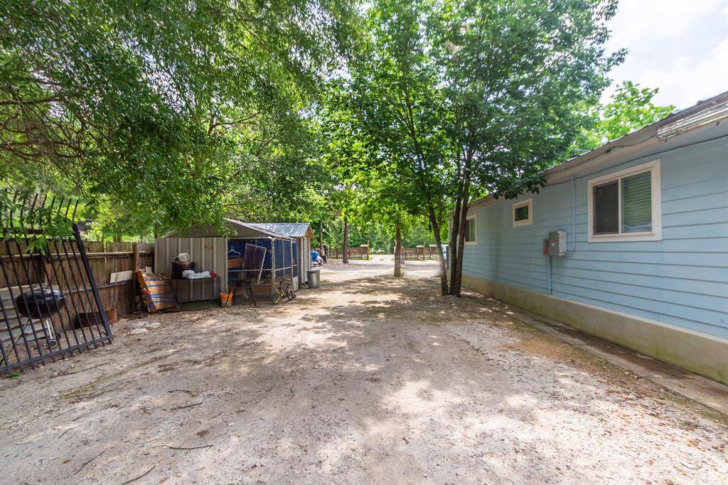 Looking towards the front from the covered porch of the back tiny home.  There's room for parking or a play ground for the children. Maybe some raised garden beds. The chain link and wooden storage do not stay with the property.