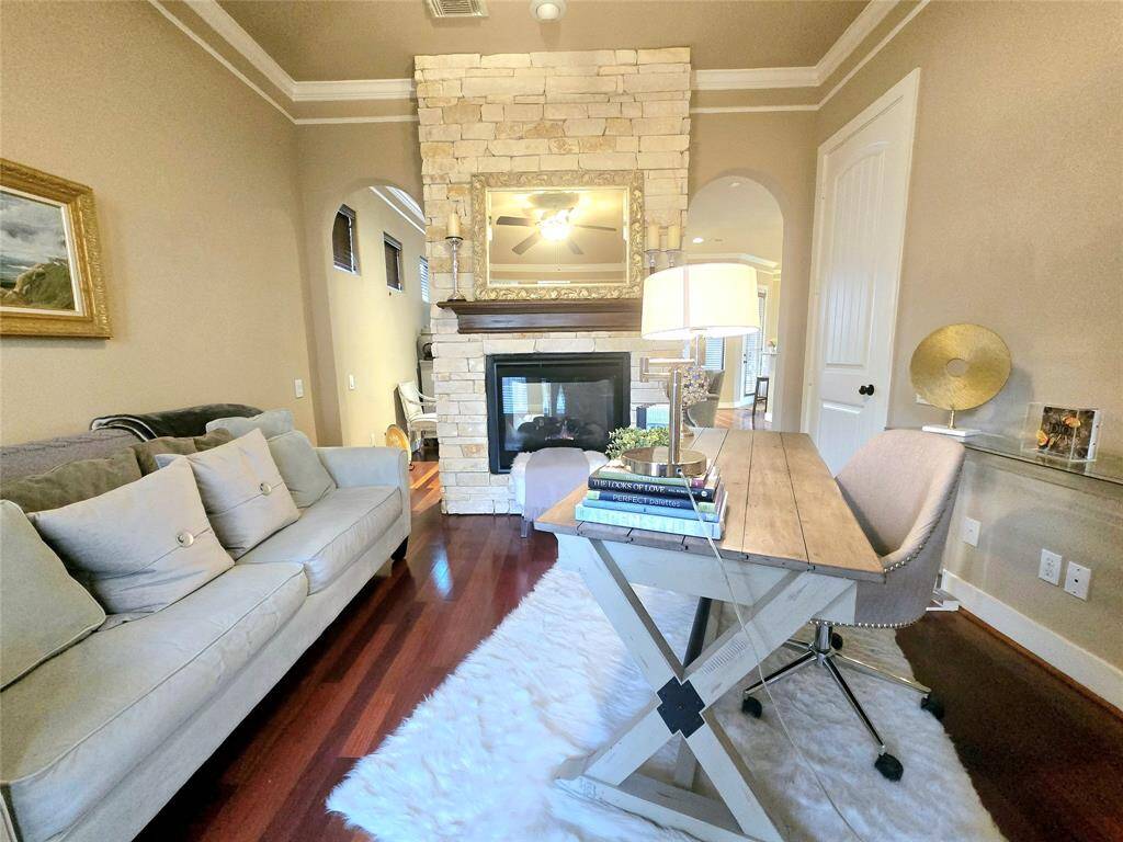 Take in the full view of this stunning office/study, from the soaring high ceilings and elegant crown moldings to the charming stone fireplace and the continued warmth of the wood floors—creating the perfect balance of style and comfort.