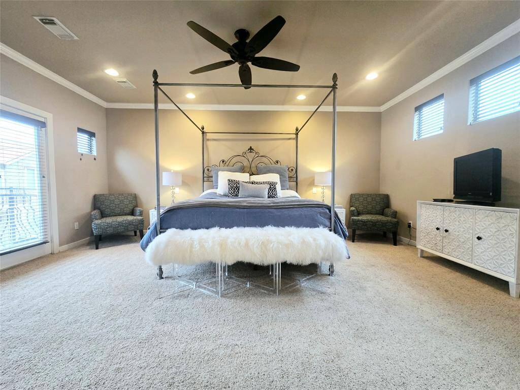 Spacious primary suite filled with rays of natural light, featuring direct access to the balcony for a serene outdoor escape.