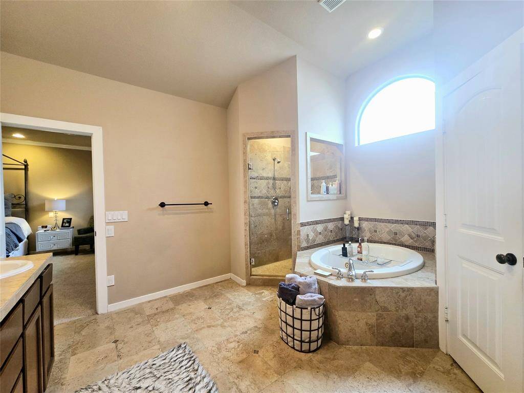 Natural lighting floods the primary bath, making it an inviting and serene space to relax and unwind.