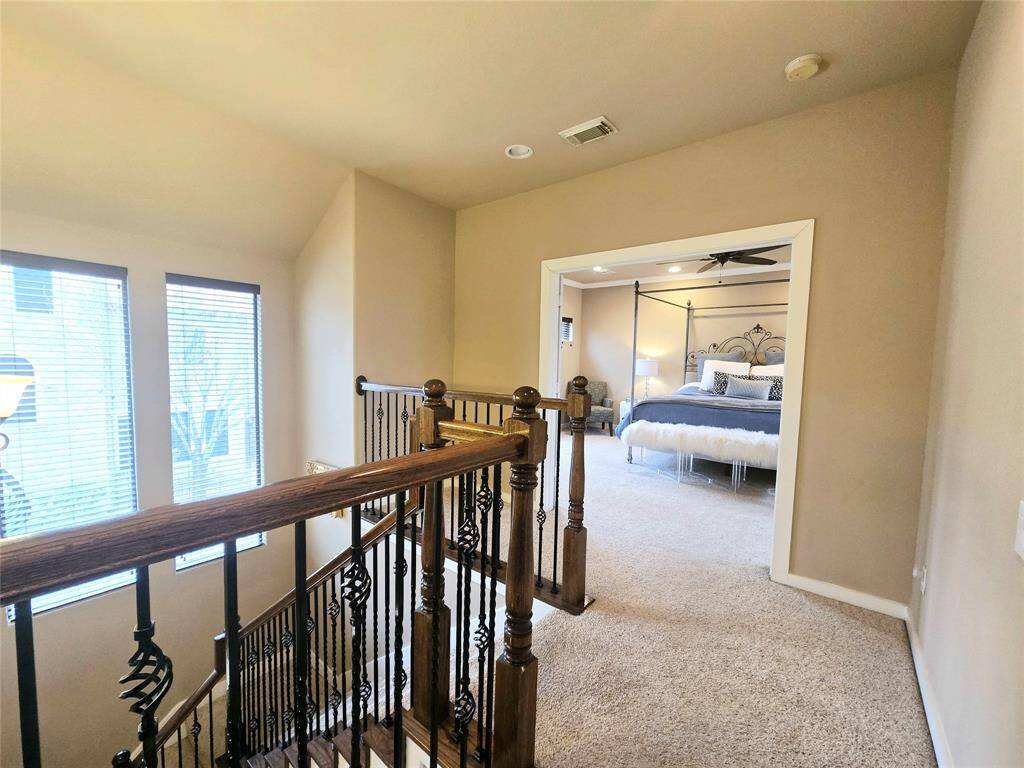 The secondary bedrooms are separated by an open hallway that overlooks the foyer, adding to the spacious and airy atmosphere of the home.