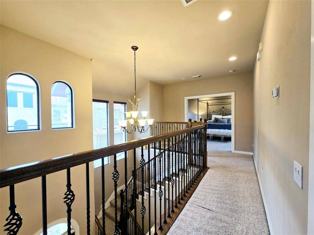 From the second floor, the foyer greets you with a gorgeous chandelier and large windows, filling the space with light and elegance.
