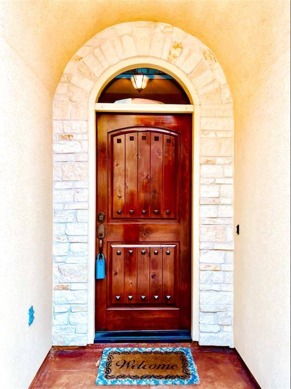 A solid wood door adorned with intricate wrought iron ornaments, blending strength with timeless elegance.