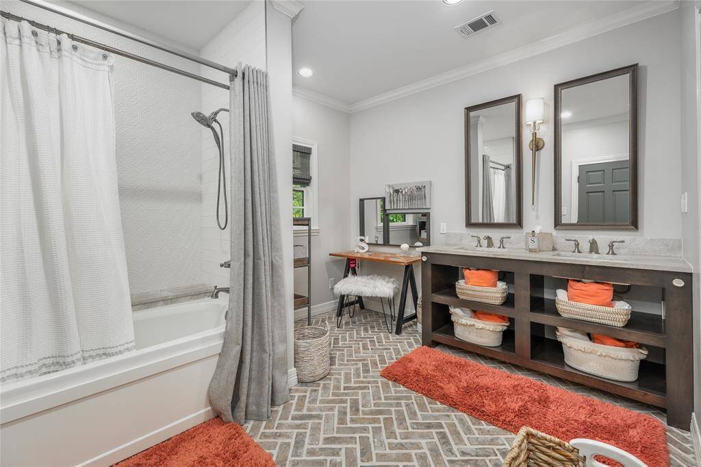 The secondary ensuite bathroom includes a double sink and space for a vanity setup.