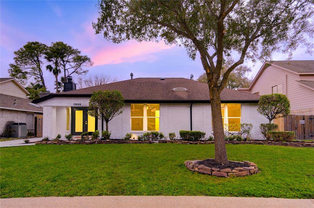 The freshly renovated exterior of this home presents a modern and inviting look, with new windows, a sleek design, and lush landscaping. The updated entryway leads to a front door that welcomes you into a beautifully renovated interior.