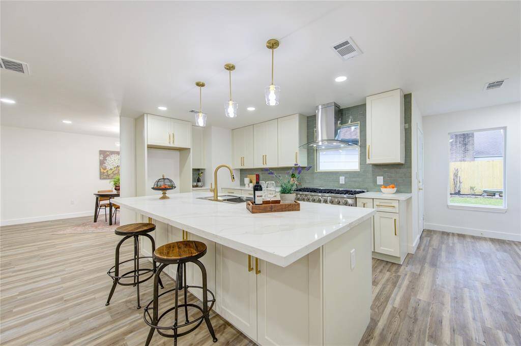 The island kitchen is designed for both style and functionality, featuring a large central island that serves as the heart of the space. The island offers extra storage with deep drawers and cabinets, providing plenty of room for kitchen essentials.