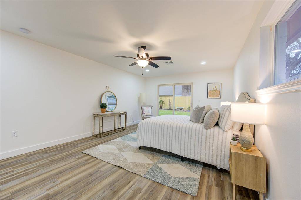 The primary bedroom features luxury vinyl flooring and large windows that bring in plenty of natural light. The freshly painted walls and updated trim provide a clean, inviting feel. This spacious room offers ample space for furniture and a relaxing retreat.