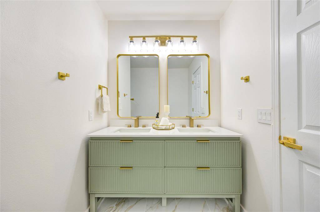 The primary bathroom features a sleek and spacious double vanity, offering plenty of room for two. The vanity is topped with Quartz countertops, providing a durable and elegant surface that complements the modern design.