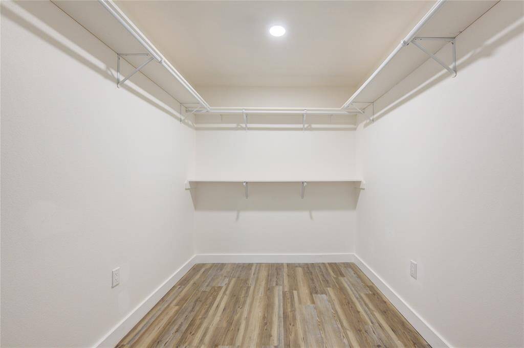The primary bedroom features a spacious walk-in closet, providing an abundance of storage space for your wardrobe and accessories. Designed with built-in shelving and hanging racks, it offers easy organization and easy access to your clothes and shoes.