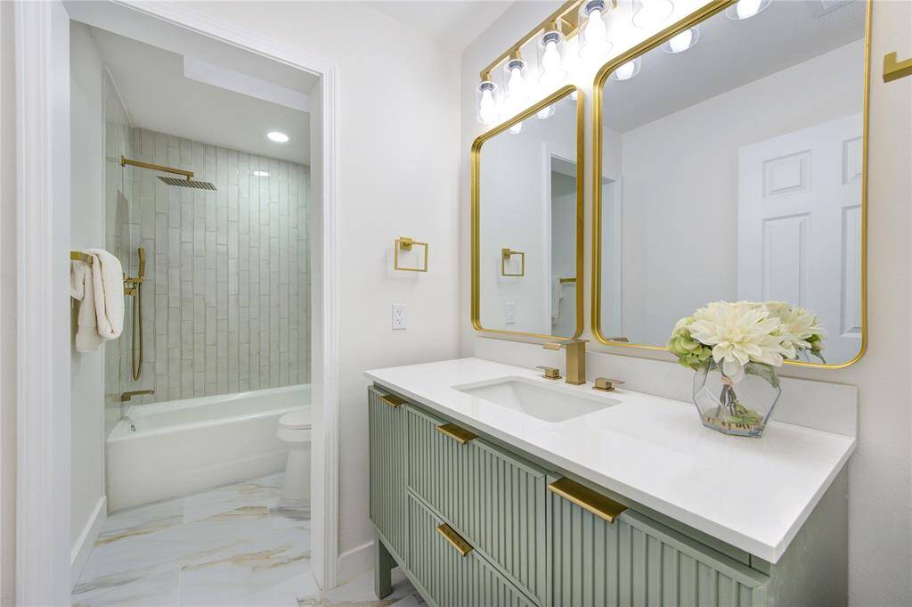 The secondary bathroom has been completely updated with new tile, a modern vanity, and Quartz countertops. A shower/tub combo with updated fixtures offers functionality while maintaining the home’s fresh and modern aesthetic.