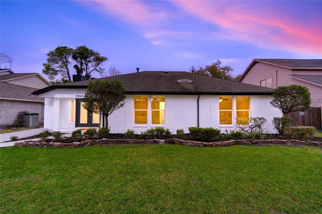 The home’s stunning front elevation showcases a timeless and modern look with its freshly painted white brick exterior. This classic yet contemporary update enhances the home’s curb appeal, giving it a clean, sophisticated aesthetic.