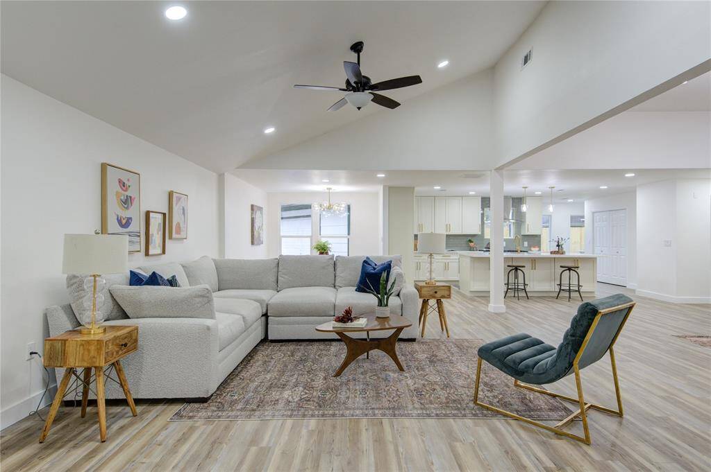 The spacious living room is flooded with natural light, thanks to new windows that create an open and airy atmosphere. The room is updated with luxury vinyl floors that flow throughout the entire home. The open-concept layout seamlessly connects the living room to the kitchen and dining areas, ideal for modern living and entertaining.