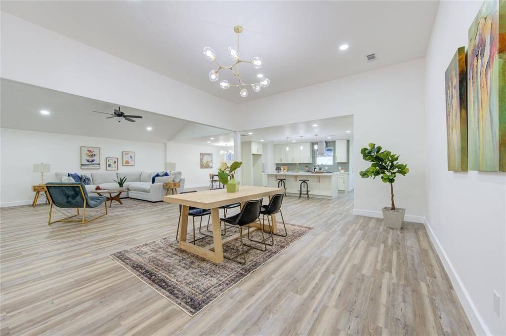 The dining room offers an elegant space for family gatherings and dinner parties. It overlooks the living room and provides access to the kitchen, offering easy flow for entertaining. The updated luxury vinyl flooring and fresh paint create a sleek, modern ambiance.