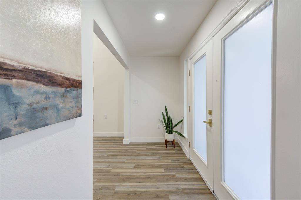 As you step through the front door, you're immediately greeted by a bright and airy entryway, bathed in natural light from the large new windows.