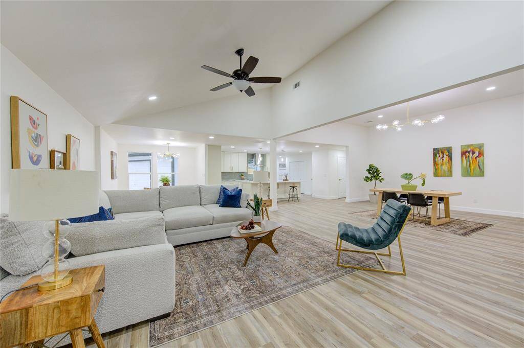 The luxury vinyl floors extend throughout the room, enhancing the modern aesthetic, while the open-concept layout allows for easy flow into the dining area and kitchen. This living room is ideal for relaxation, entertaining, or enjoying cozy nights by the fire.