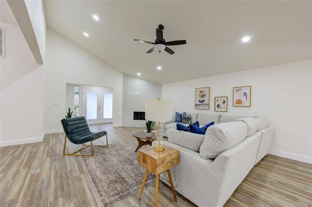 The spacious living room is the heart of this home, offering an abundance of natural light thanks to the large new windows. The room features an updated modern fireplace, adding both warmth and style to the space. The sleek, minimalist design of the fireplace complements the home’s contemporary vibe, making it a perfect focal point for gatherings.