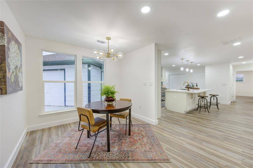 The luxury vinyl flooring continues seamlessly from the kitchen into the breakfast room, creating a cohesive flow. With its open layout, this space is ideal for family meals or as a cozy nook for reading and relaxing. The fresh paint and modern finishes ensure this room is both stylish and functional.