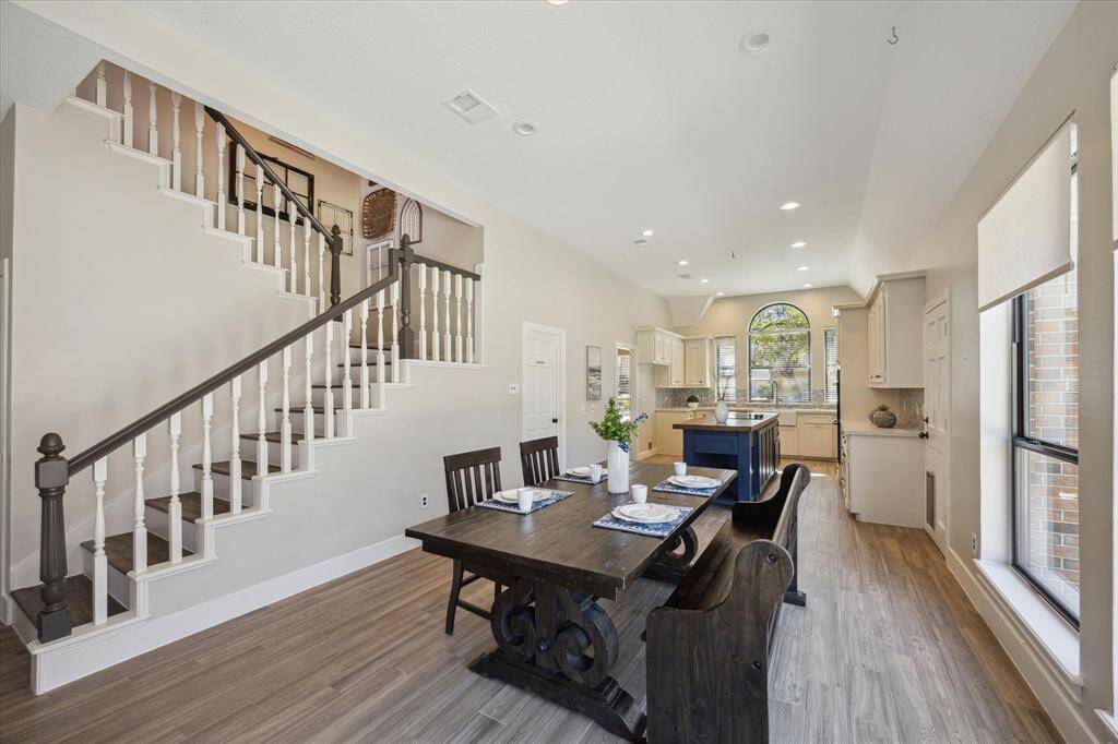 The bright breakfast room blends style and comfort, with large windows, custom electric shades, and a second staircase leading to the game room and three bedrooms.