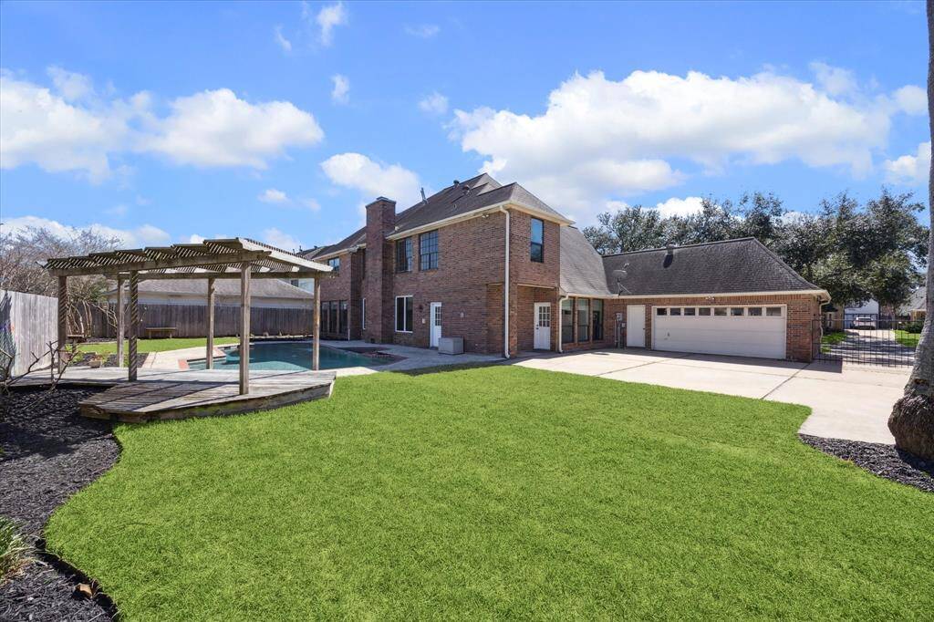 Even with all the backyard improvements, there's still plenty of greenspace for pets or kids to play. Take note of the gated driveway that leads to the garage.