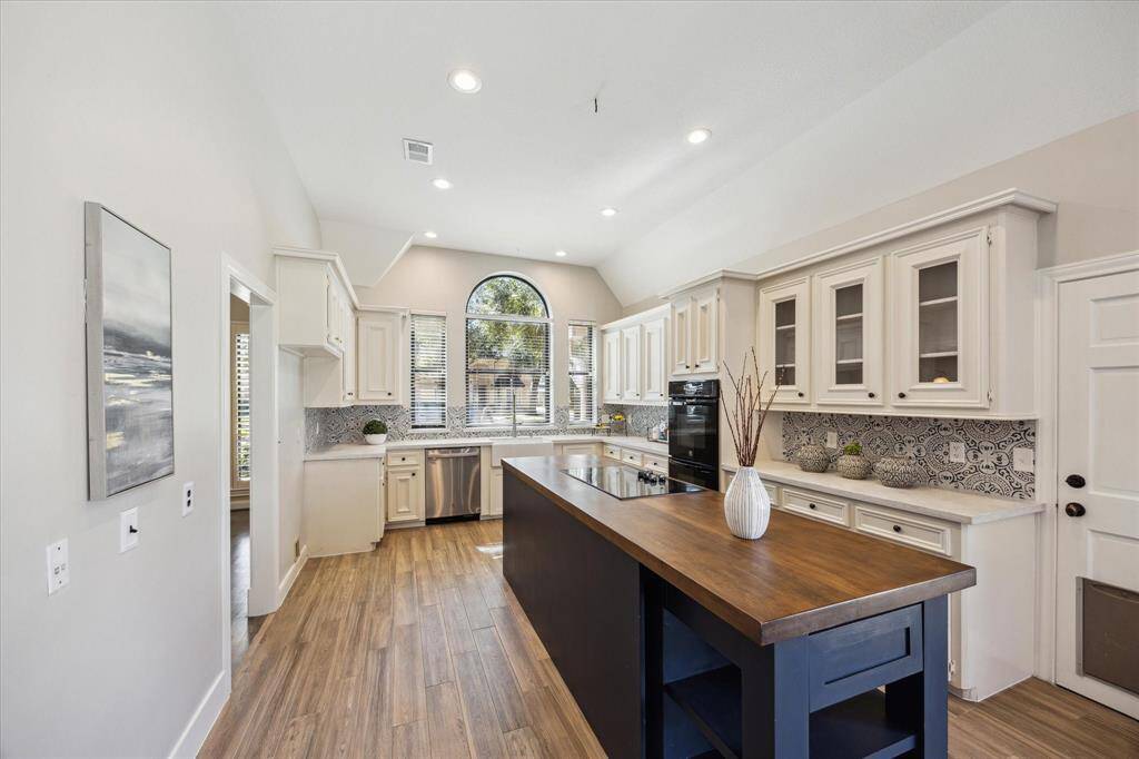 The spacious island with an electric cooktop is perfect for cooking while entertaining. A custom tile backsplash adds both style and function.